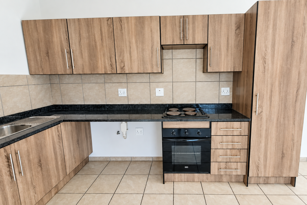Modern kitchen featuring wood-look cabinetry, dark granite countertops, built-in oven and hob, tiled backsplash, and dedicated plumbing for an appliance.