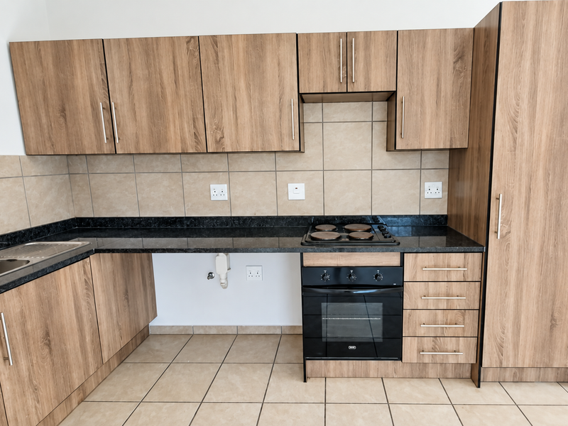 Modern kitchen featuring wood-look cabinetry, dark granite countertops, built-in oven and hob, tiled backsplash, and dedicated plumbing for an appliance.