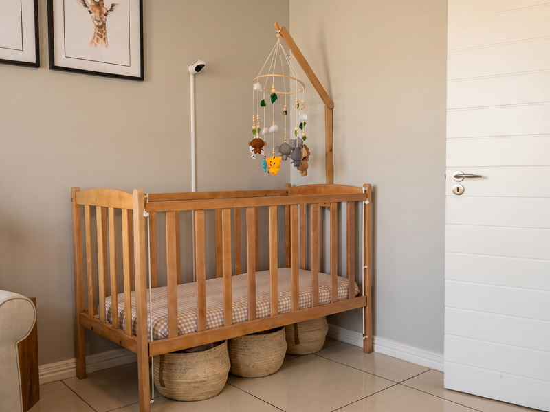 A well-maintained bedroom featuring neutral wall tones, tiled flooring, and a clean, modern internal door.