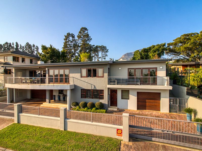 A well-maintained double-story residence featuring a paved driveway, double garage, and upper-level balconies with modern architectural finishes.