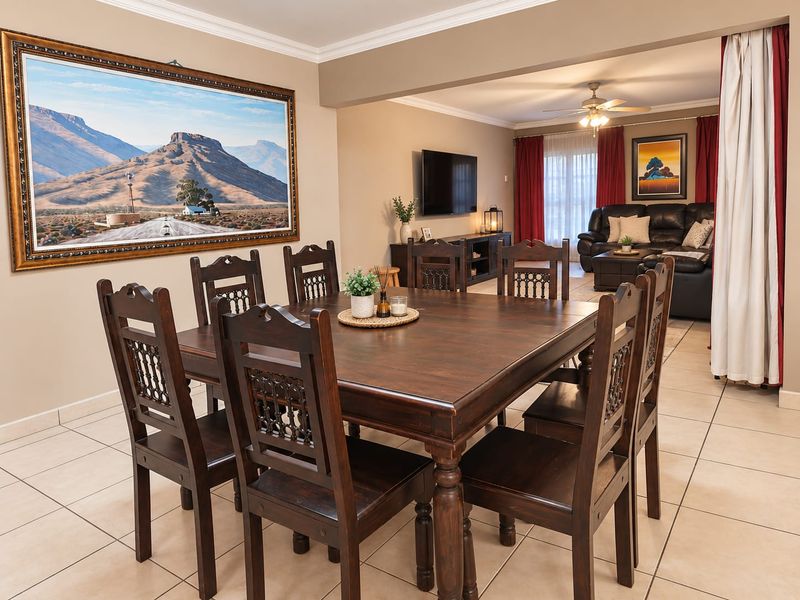Spacious open-plan dining and living area featuring neutral tiled flooring, decorative ceiling cornices, and a ceiling fan, creating a comfortable and connected living space.
