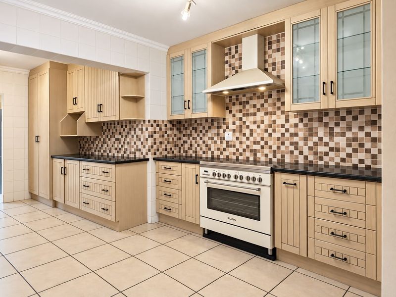 A well-maintained kitchen featuring light wood cabinetry, a tiled backsplash, granite countertops, and a built-in oven with an extractor fan.