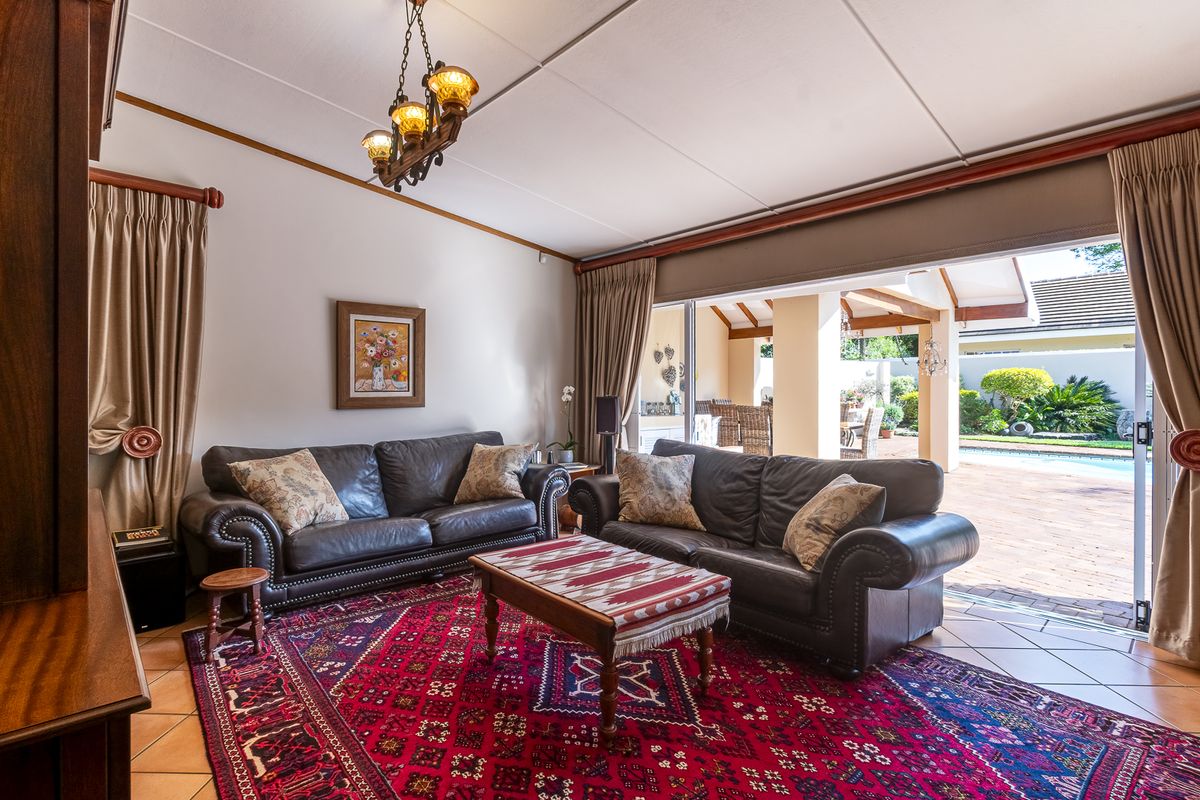 Spacious living room featuring tiled flooring and large sliding glass doors that provide seamless access to the outdoor patio and pool area.