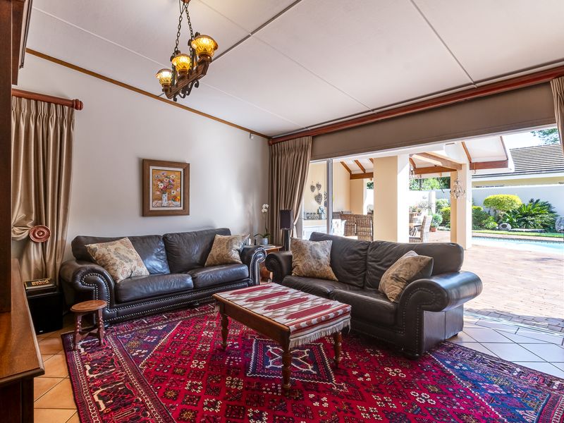 Spacious living room featuring tiled flooring and large sliding glass doors that provide seamless access to the outdoor patio and pool area.