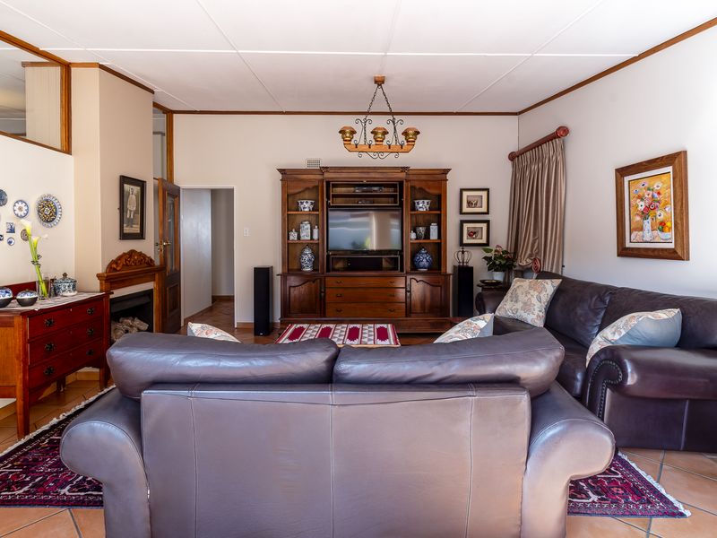 A traditional living room featuring tiled flooring, a fireplace, and built-in cabinetry, offering a comfortable and functional space for relaxation.
