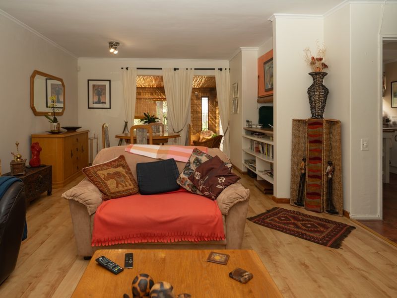 A comfortable living room featuring laminate flooring, built-in shelving, and sliding glass doors that provide access to an outdoor patio area.