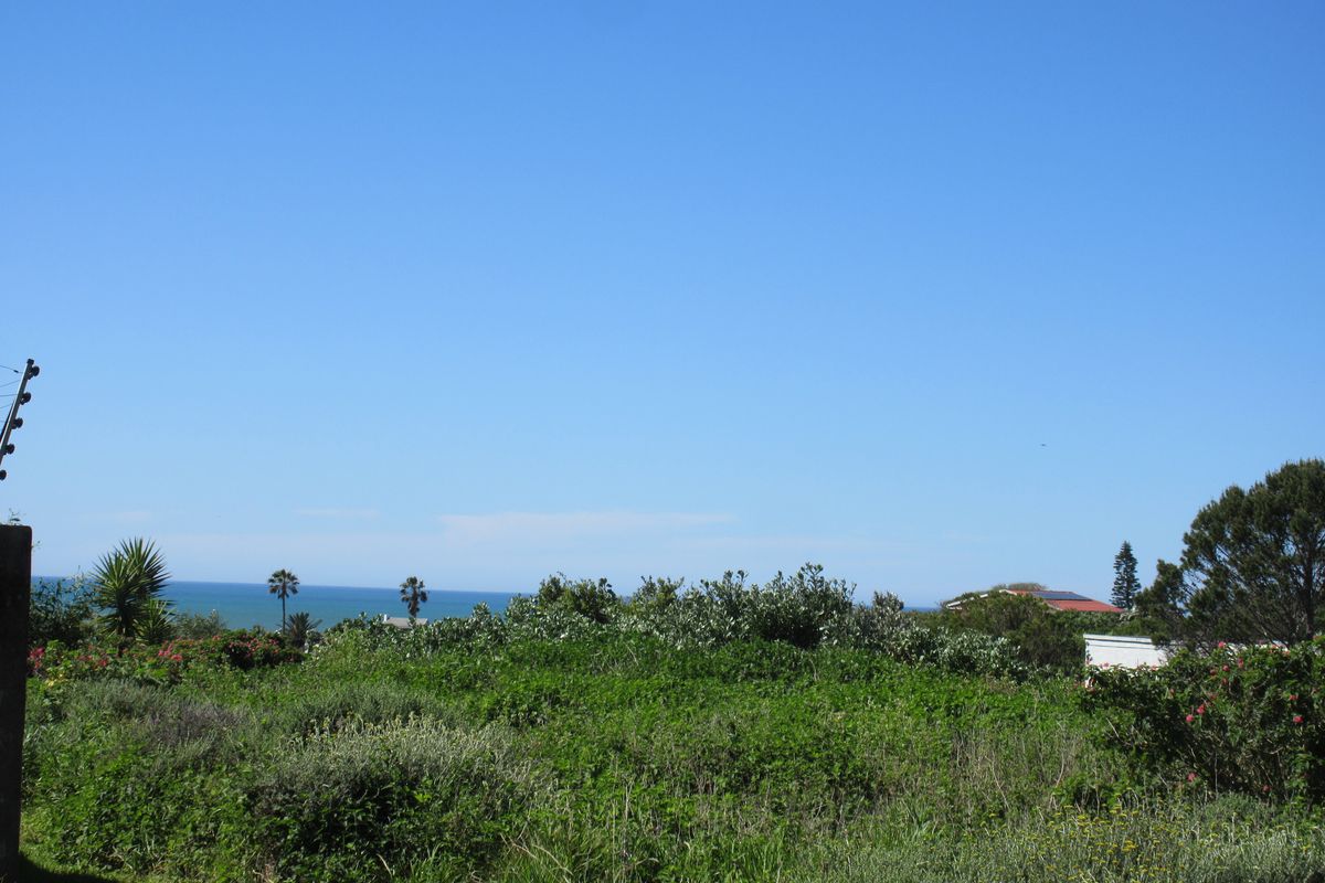 A view of the coastal landscape and ocean horizon from the vacant residential property, featuring natural vegetation and perimeter electric fencing.
