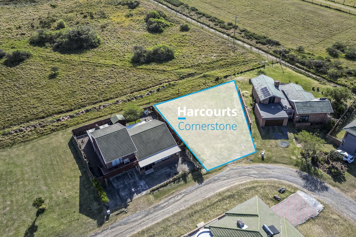 An aerial view of a vacant residential plot situated within a developed estate, highlighting the available land area and surrounding neighborhood context.