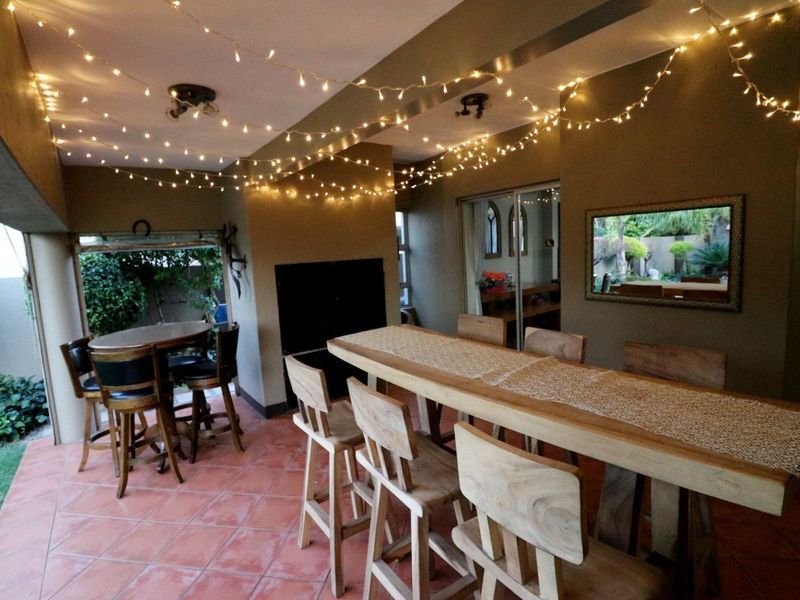 Covered patio area featuring a built-in braai, tiled flooring, and sliding glass doors providing access to the interior living space.