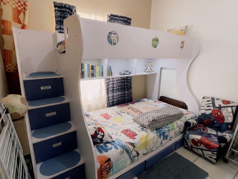 A bedroom featuring tiled flooring and a window with curtains.