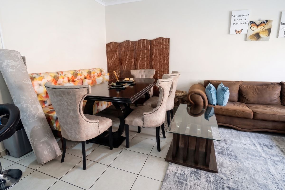 Open plan living and dining area featuring neutral tiled flooring, providing a versatile space for relaxation and entertaining.