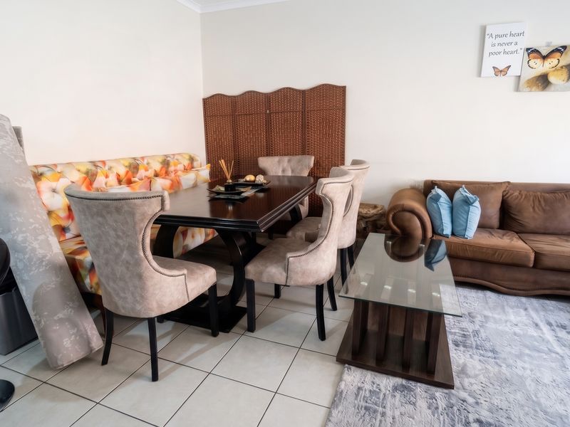 Open plan living and dining area featuring neutral tiled flooring, providing a versatile space for relaxation and entertaining.