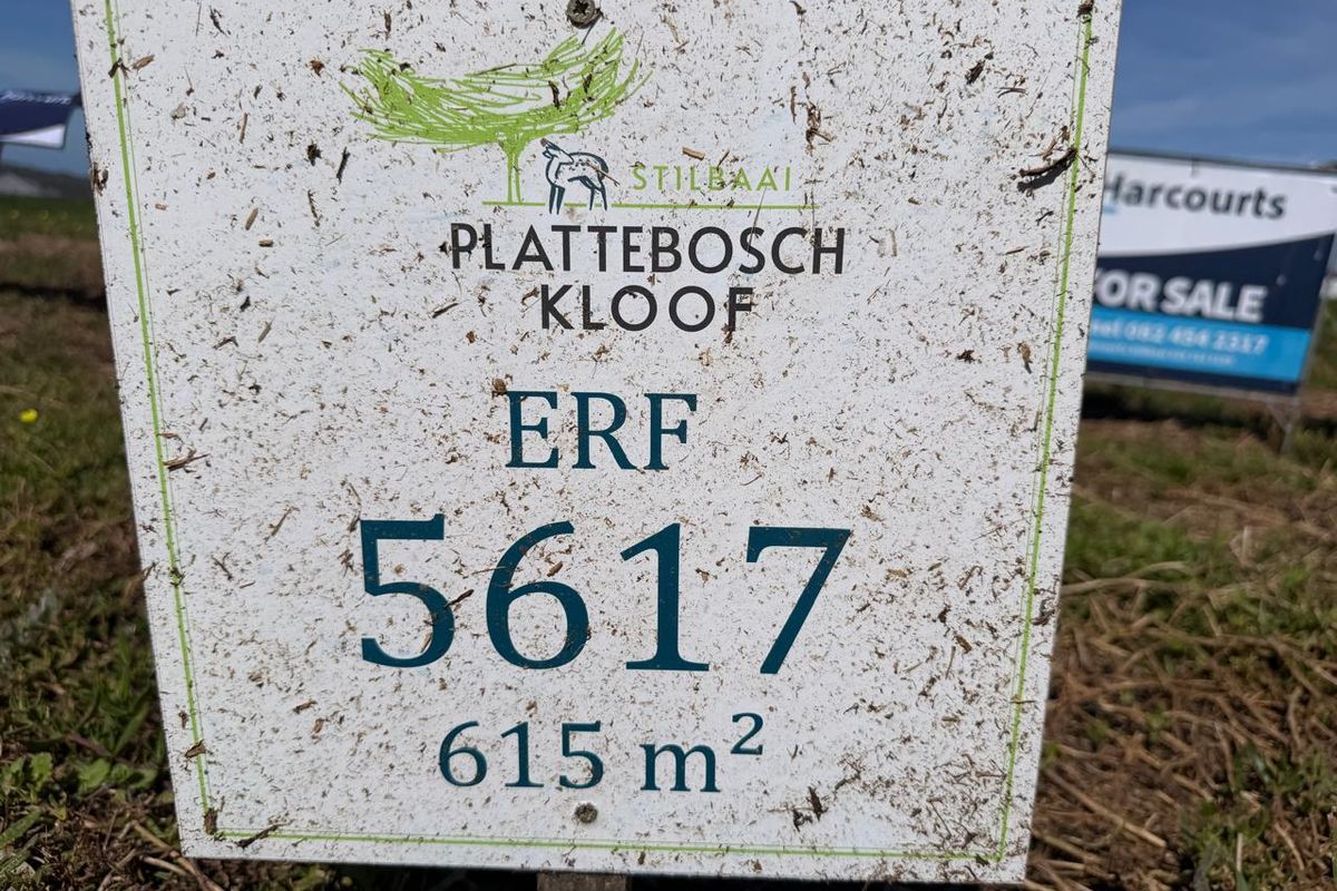 A close-up view of a property signage board for a vacant residential plot in Plattebosch Kloof, Stilbaai, measuring 615 square meters.