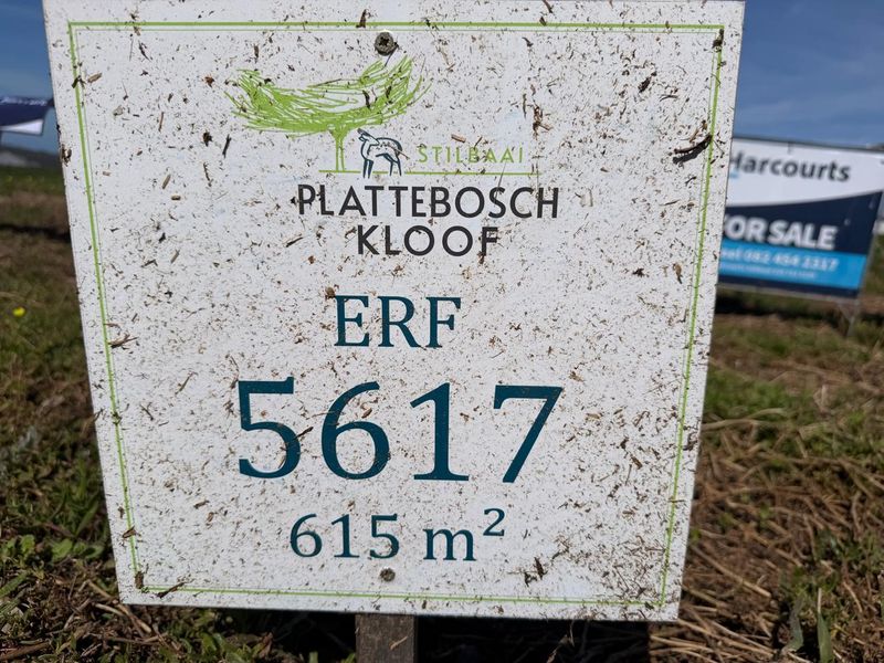 A close-up view of a property signage board for a vacant residential plot in Plattebosch Kloof, Stilbaai, measuring 615 square meters.