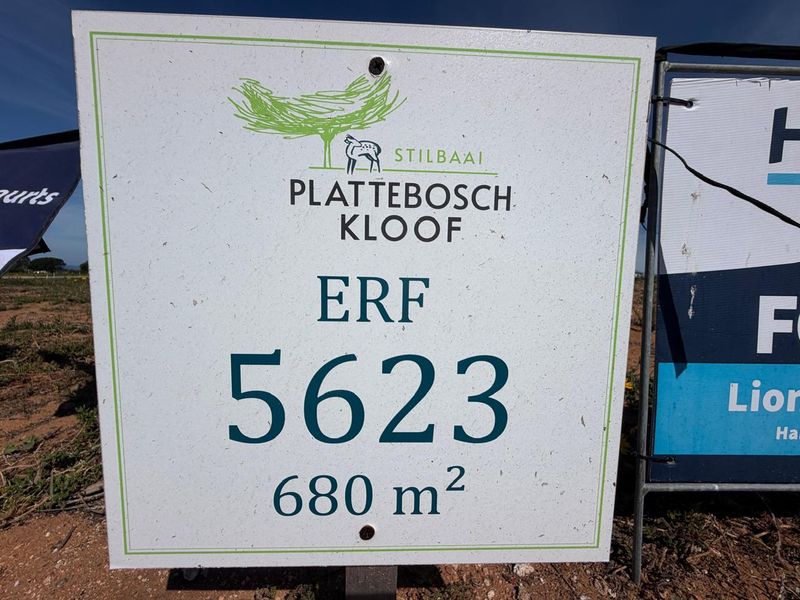 A real estate signage board displaying the erf number 5623 and land size of 680 square meters in Plattebosch Kloof, Stilbaai.