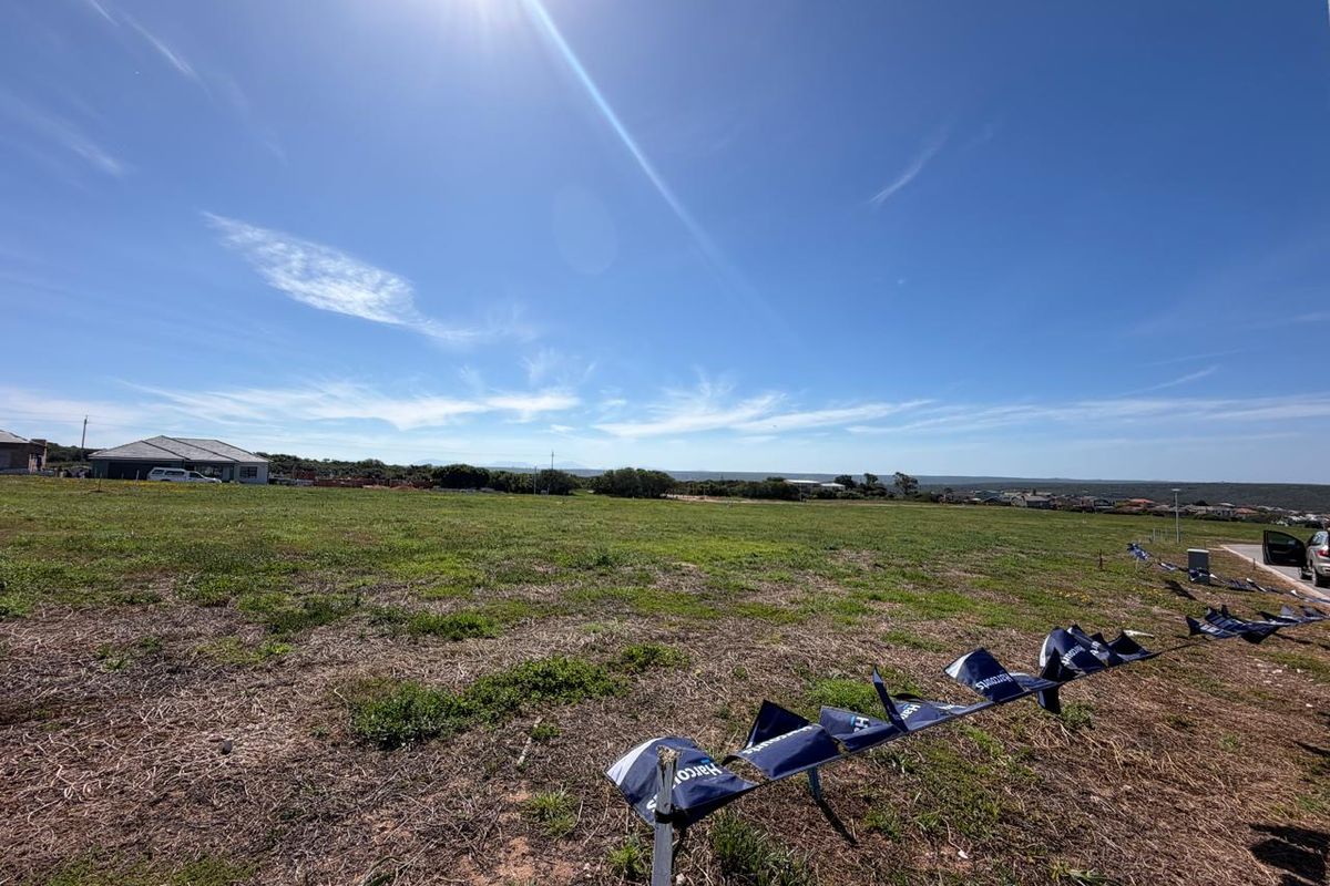 A wide-angle view of a vacant residential plot of land with clear boundaries and surrounding neighborhood views.