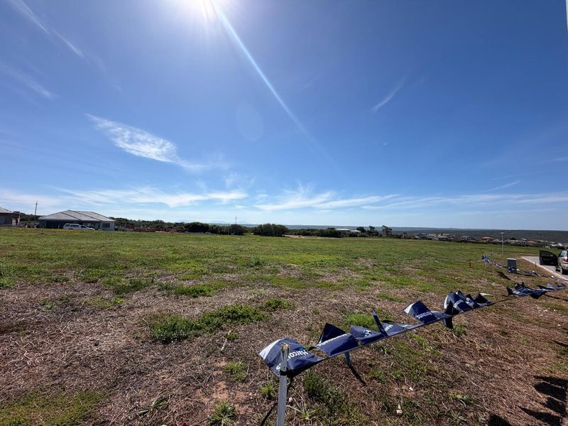 A wide-angle view of a vacant residential plot of land with clear boundaries and surrounding neighborhood views.