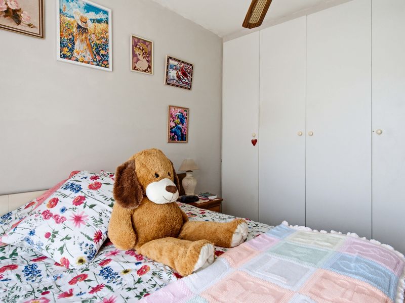 A bedroom featuring built-in cupboards and a ceiling fan, providing functional storage and climate control.