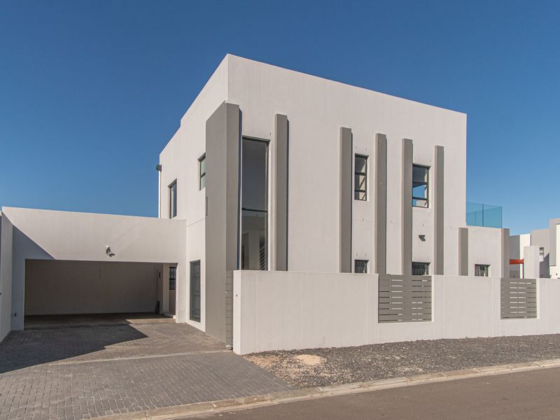 Modern double-storey residential property featuring a clean architectural facade, paved driveway, and integrated double garage with contemporary boundary wall detailing.