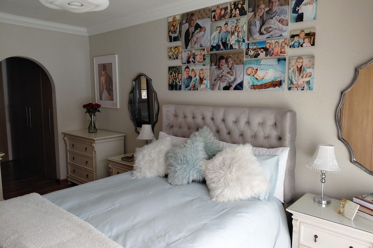 A well-maintained bedroom featuring an arched doorway, decorative coving, and a central ceiling light fixture.