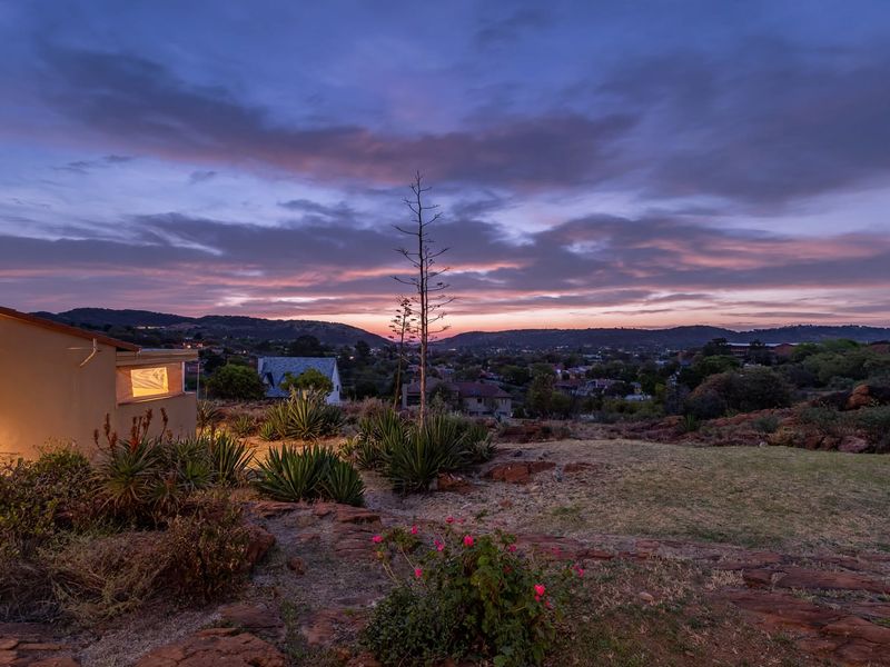 A scenic sunset view overlooking the surrounding landscape and residential area, captured from the property grounds.