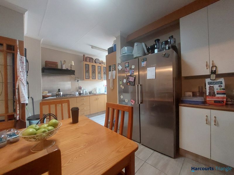 A functional kitchen featuring built-in cabinetry, laminate countertops, and tiled flooring, providing a practical workspace with integrated storage and appliance space.