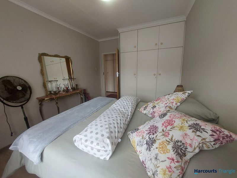 A bedroom featuring built-in cupboards and coved ceiling details, offering a functional space with neutral wall finishes.