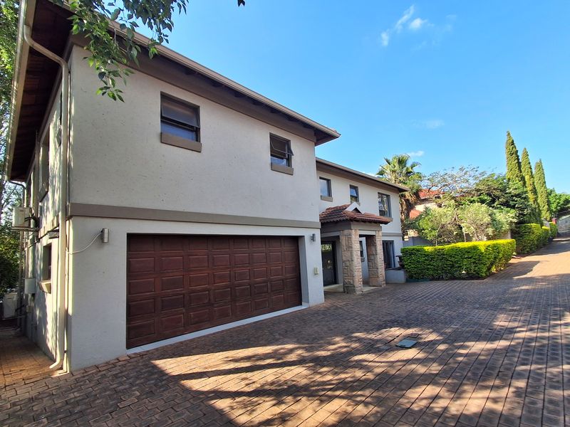 Front elevation of a two-story house featuring a double garage, stone-clad entrance detail, and a paved driveway.