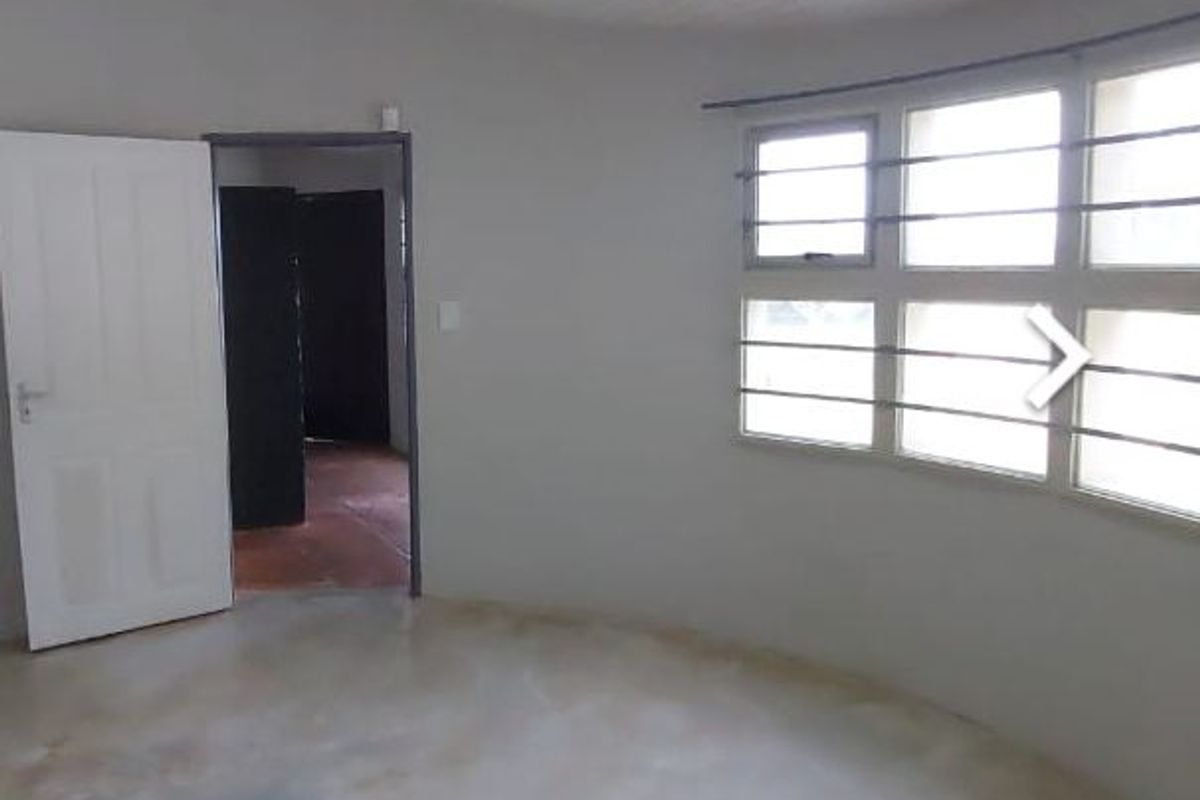 An empty bedroom featuring a tongue and groove ceiling, security bars on the windows, and polished concrete flooring.