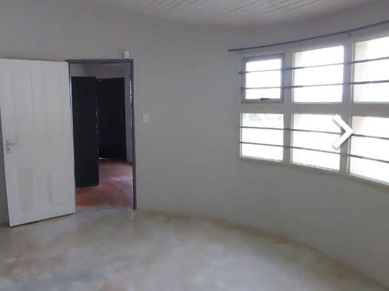 An empty bedroom featuring a tongue and groove ceiling, security bars on the windows, and polished concrete flooring.