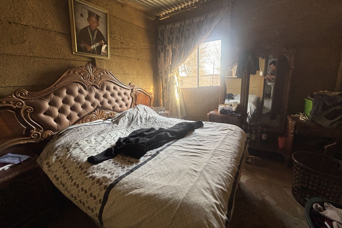 A bedroom featuring exposed brick walls and a corrugated metal ceiling, offering a rustic aesthetic that could be enhanced with modern finishes.