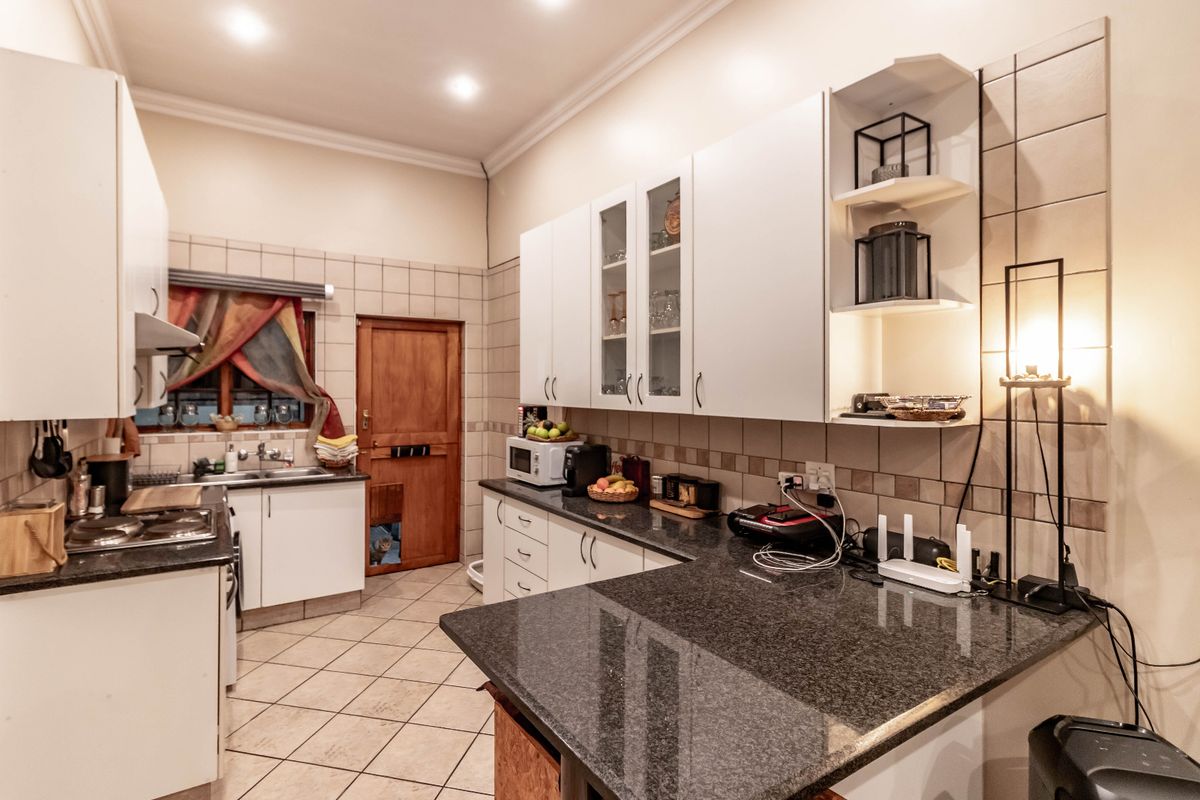 A functional kitchen featuring granite countertops, ample built-in cabinetry, tiled backsplash, and recessed lighting, providing a practical workspace for daily cooking.