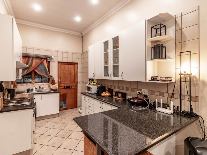 A functional kitchen featuring granite countertops, ample built-in cabinetry, tiled backsplash, and recessed lighting, providing a practical workspace for daily cooking.