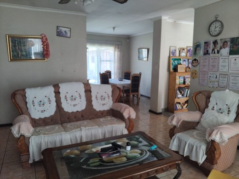 Open plan living and dining area featuring tiled flooring and neutral wall finishes, providing a functional and connected layout for family living.