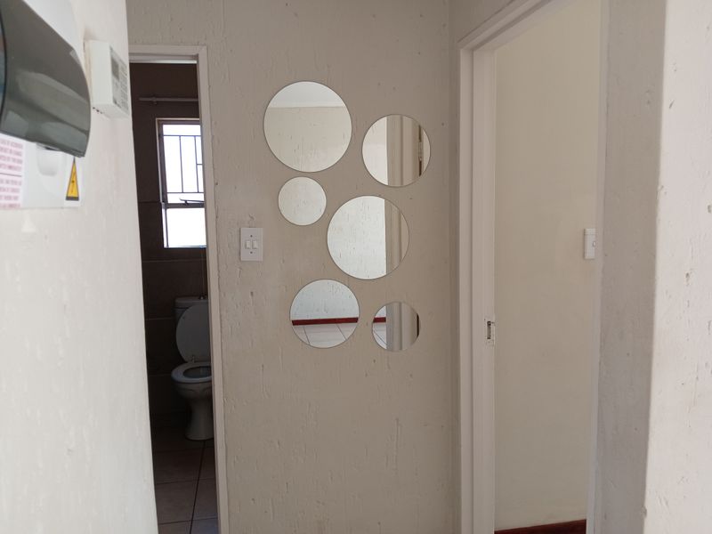 A simple hallway area featuring textured walls and access to an adjacent bathroom, providing a functional transition space within the townhouse.