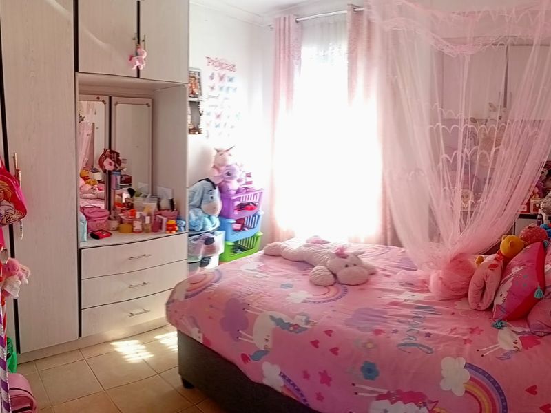 A bedroom featuring built-in cupboards and tiled flooring, currently styled as a child's room.