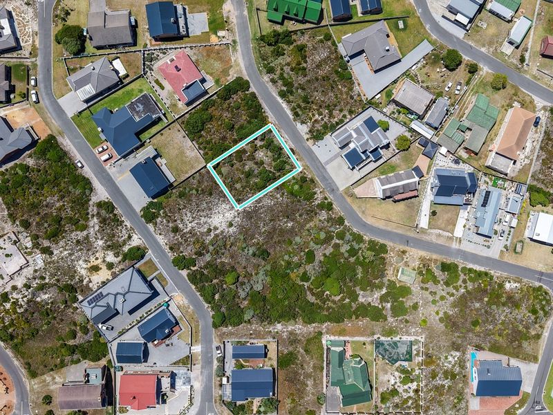 Aerial view of a vacant residential plot in a developed neighborhood, highlighting the property boundaries and surrounding residential infrastructure.