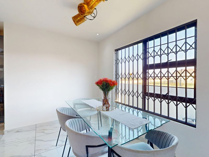 A bright dining area featuring marble-look floor tiles, a built-in display cabinet, and a window fitted with a security gate.