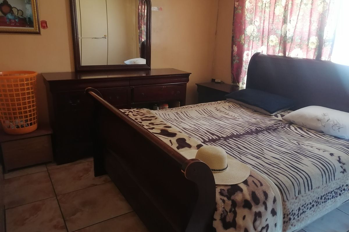 A bedroom featuring tiled flooring and neutral wall finishes, providing a functional space for rest.