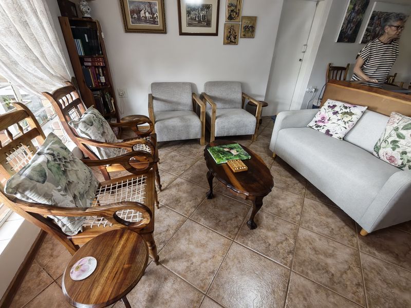A comfortable living room area featuring ceramic floor tiles and a built-in shelving unit, providing a functional and inviting space.