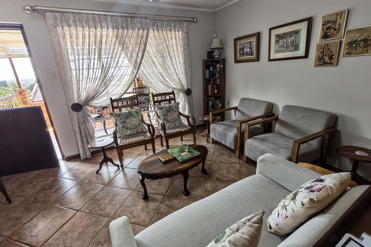 A comfortable living room featuring tiled flooring and a large sliding glass door that provides access to an outdoor patio area.