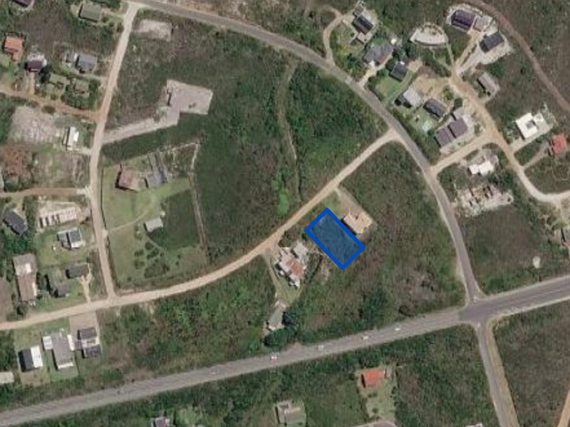 Aerial view of a vacant residential land plot highlighted in blue, situated within a developing suburban neighborhood.