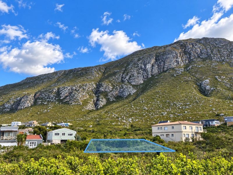 A vacant plot of land situated in a residential area with a prominent mountain backdrop.