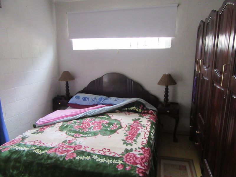 A functional bedroom featuring a built-in wardrobe and a roller blind, providing a simple and practical sleeping space.