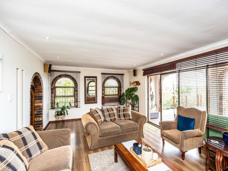 A comfortable living room featuring laminate flooring, recessed lighting, and sliding glass doors that provide access to an outdoor area.