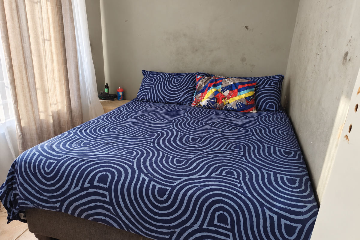 A bedroom featuring tiled flooring and walls showing visible signs of staining and surface wear, requiring cosmetic attention.
