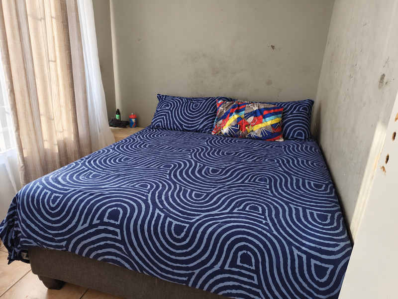 A bedroom featuring tiled flooring and walls showing visible signs of staining and surface wear, requiring cosmetic attention.