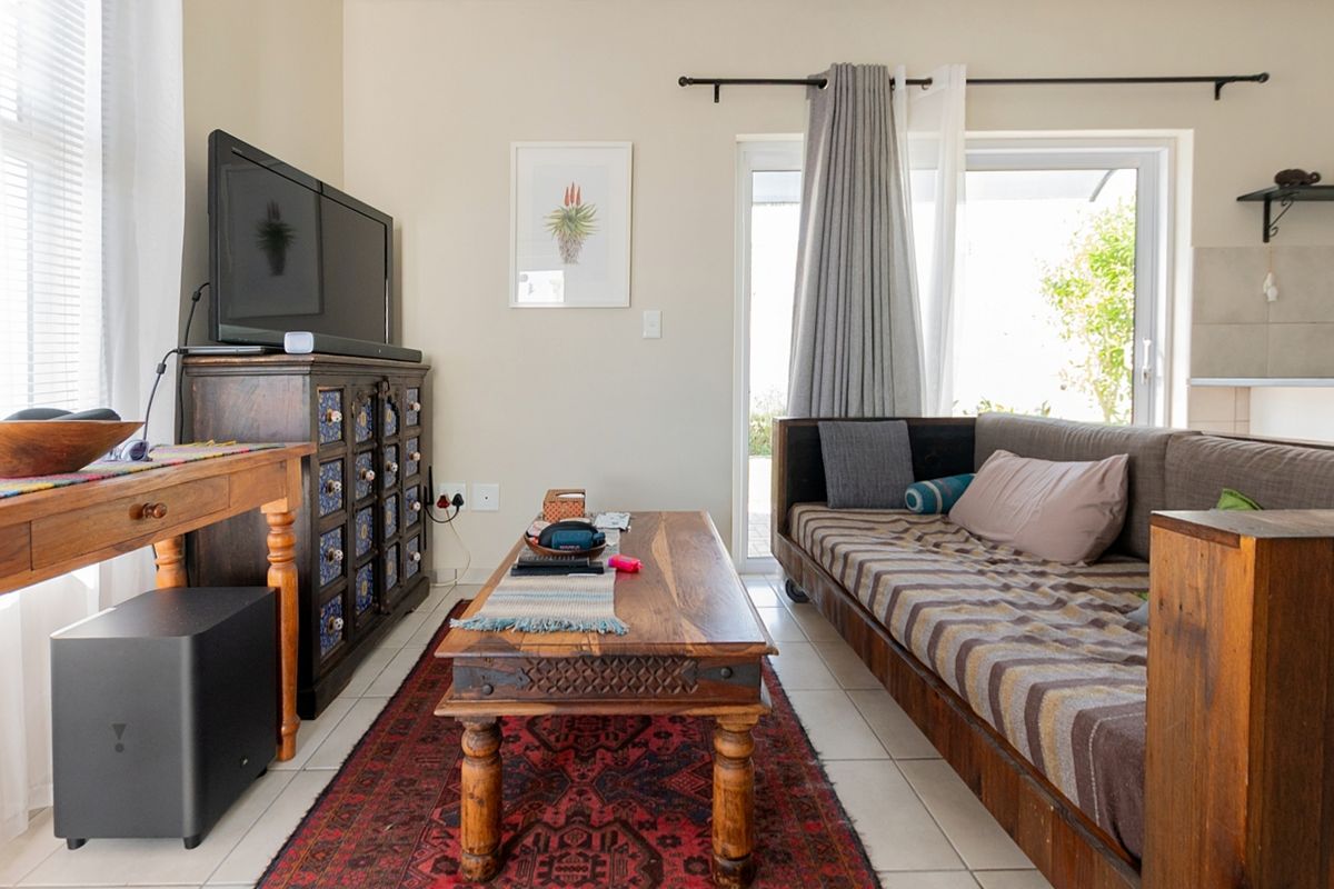 A comfortable living room featuring tiled flooring and a sliding glass door that provides natural light and access to the outdoor area.