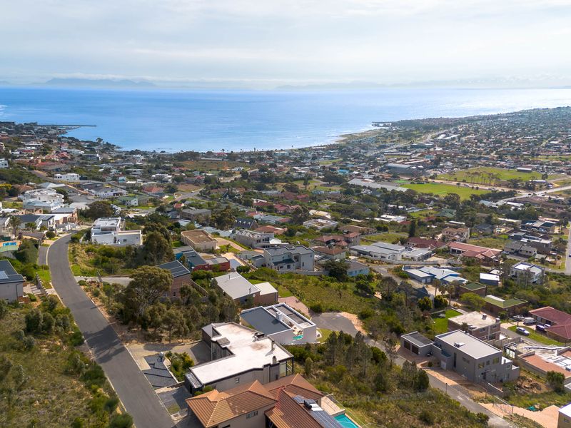 An elevated aerial view showcasing the coastal residential neighborhood, surrounding landscape, and proximity to the ocean.