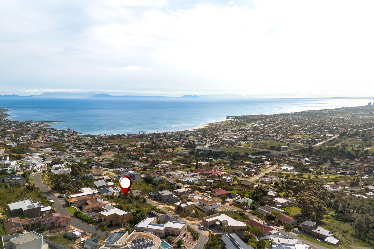 An aerial view of a residential neighborhood situated along the coastline, highlighting the property location and surrounding landscape.